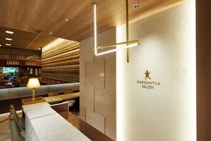 Un interior moderno con un mostrador de recepción, un área de estar y una pared con el texto "BARGANTUA SALON".
