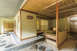 A traditional Japanese room with tatami flooring, a low wooden table, and sliding doors.
