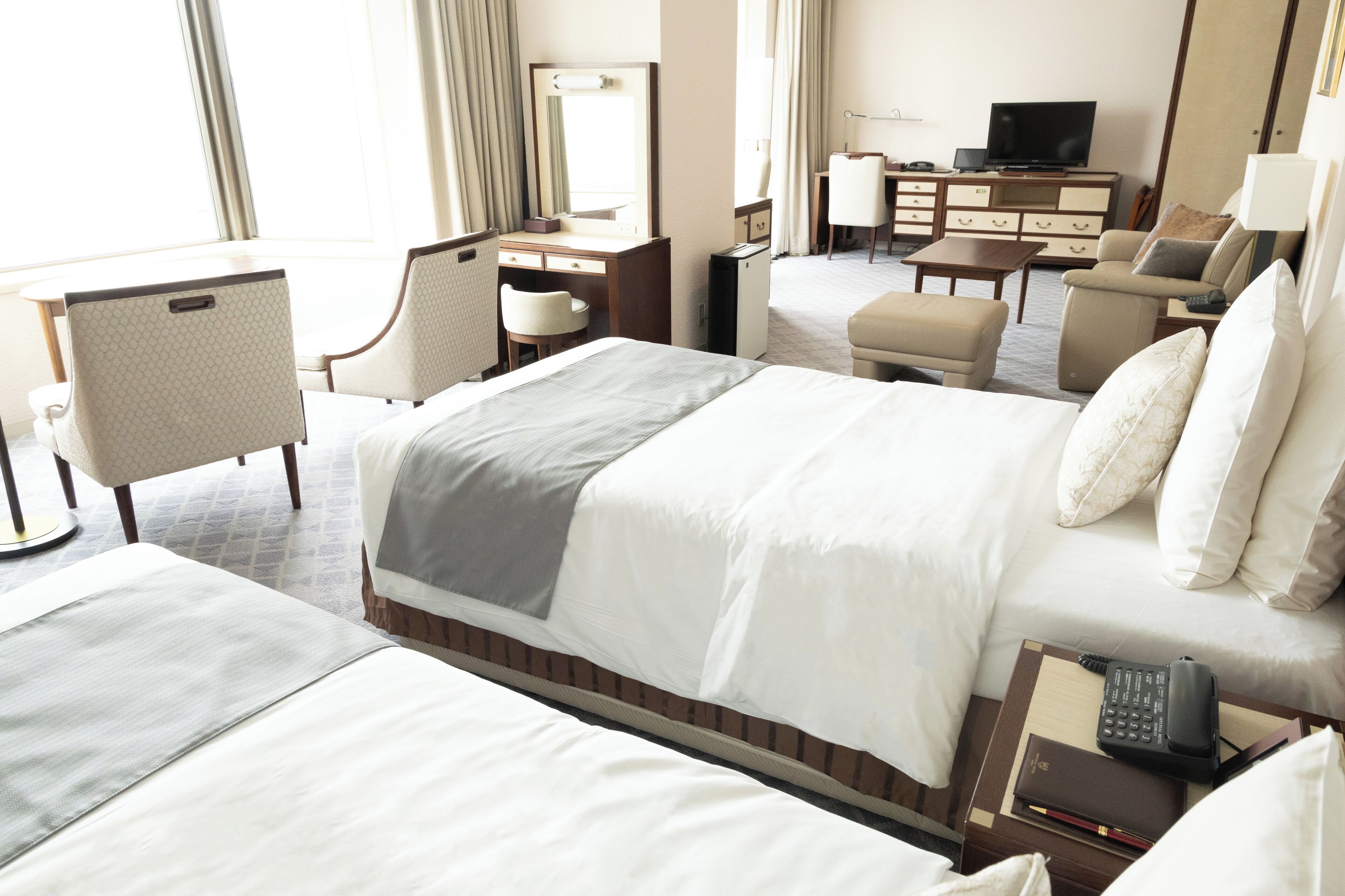 Une chambre d’hôtel avec un grand lit, un bureau, une chaise, une télévision et une lampe de bureau.