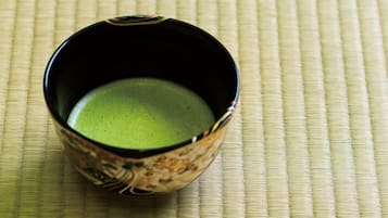 A cup of green tea on a woven mat.
