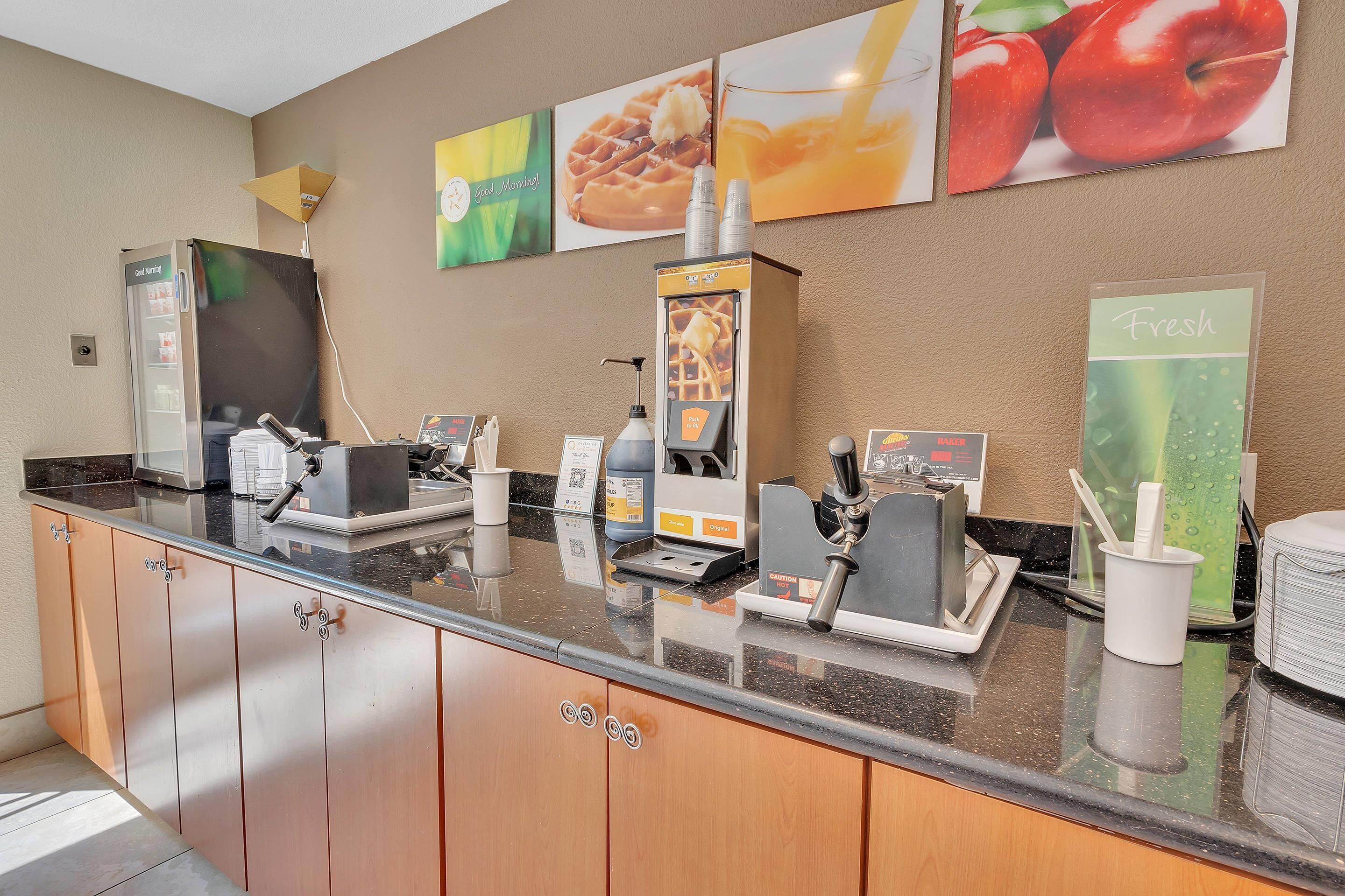 A hotel reception area with a coffee machine, a refrigerator, and a menu board.