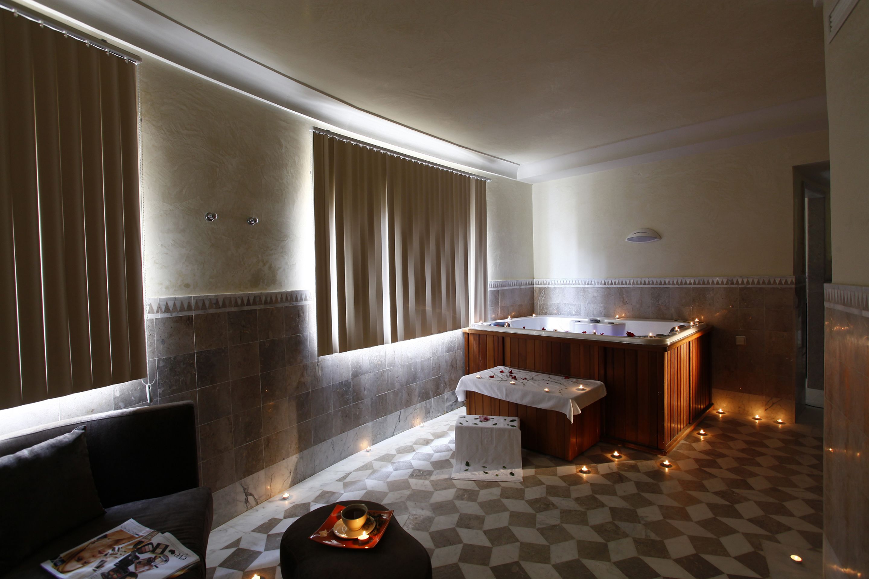 A modern bathroom with a freestanding bathtub, a vanity with a mirror, and a checkered floor.