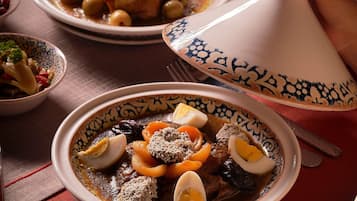A traditional Moroccan tagine dish with eggs, vegetables, and meat, served in a patterned bowl.