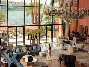 A spacious lobby with a grand chandelier, seating areas, and a view of the water. - Sofitel Cairo Nile El Gezirah (Cairo)