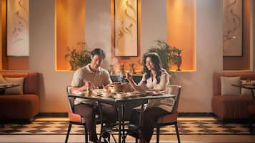 A dining area with a checkered floor, a round table, and two people seated.