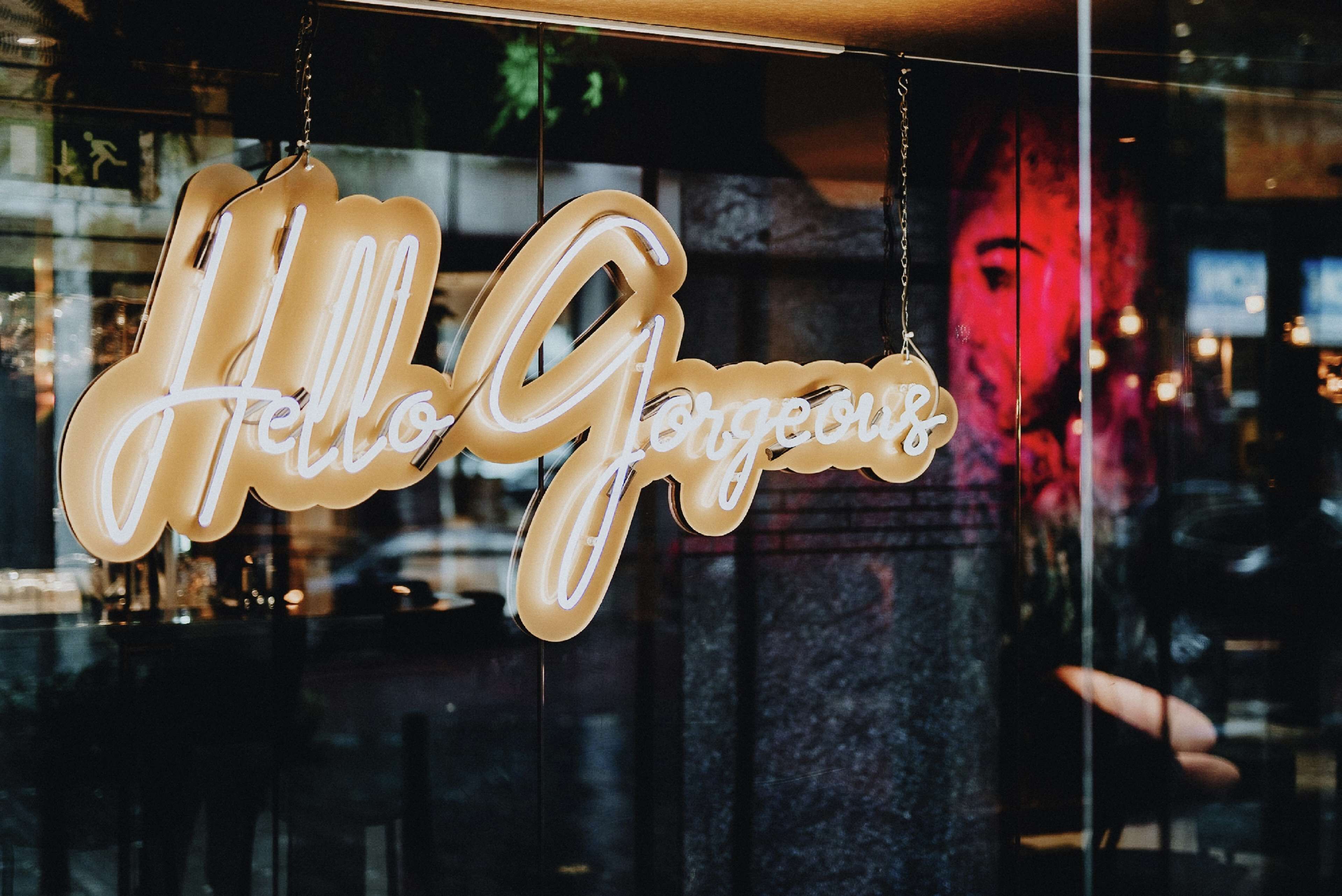 Een neonbord met de tekst 'Hello Gorgeous' in sierletters.