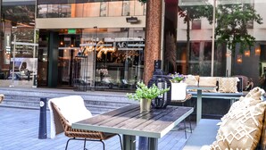 An outdoor seating area with a table, chairs, and a sofa. - Hilton Rotterdam (Rotterdam)