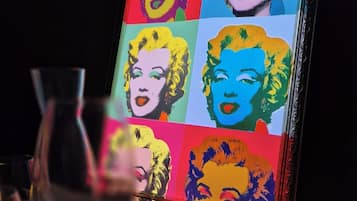 A framed pop art piece with a grid of colorful portraits.