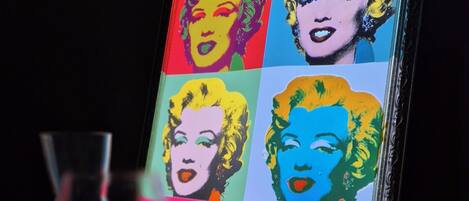 A framed pop art piece with a grid of colorful portraits.