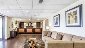 A hotel lobby with a reception desk, a sofa, a coffee table with flowers, and framed artwork on the walls. - Quality Inn Chillicothe (Chillicothe)