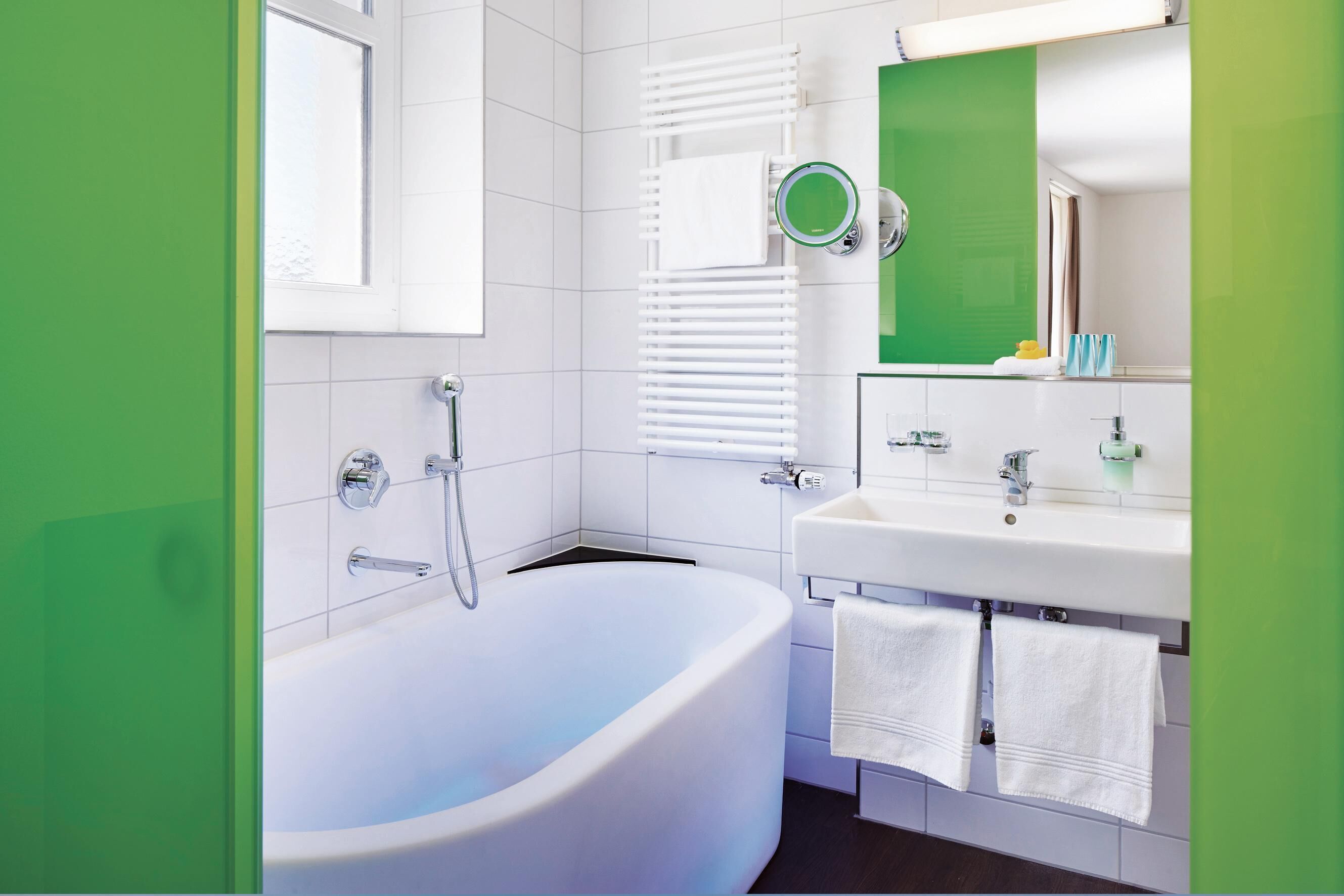 Un baño moderno con una bañera independiente, un lavabo y un espejo.