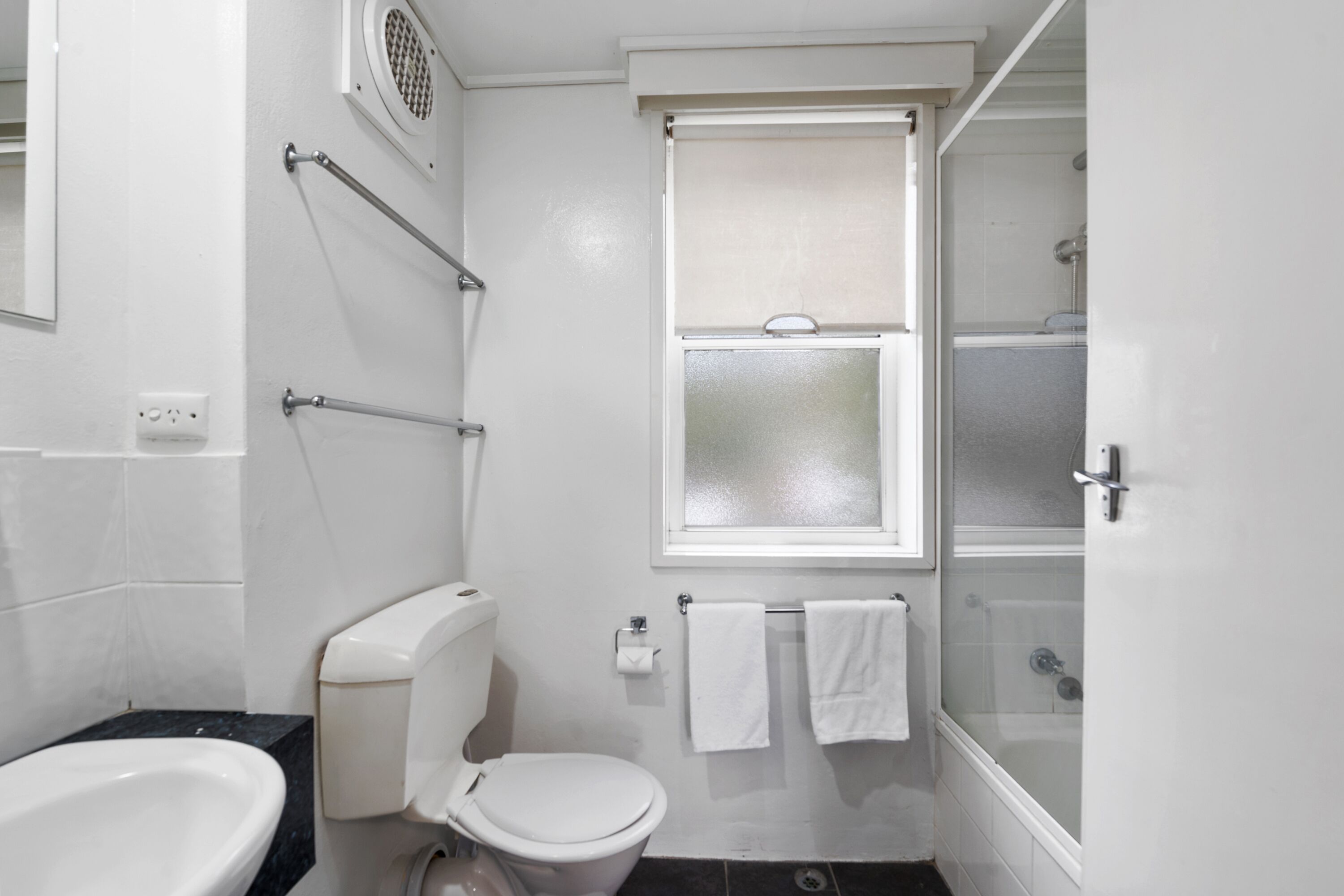A bathroom with a toilet, bidet, and shower.