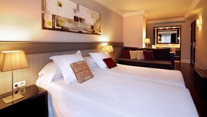 Habitación de hotel con dos camas, un espejo grande y una obra de arte colgada en la pared.