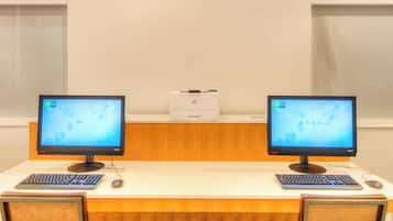 Et værelse med to skriveborde, hver med en computerskærm, tastatur og mus.