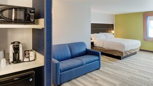 A hotel room with a bed, a blue sofa, a microwave, and a coffee machine. - Holiday Inn Express Newberg - Wine Country by IHG (Newberg)