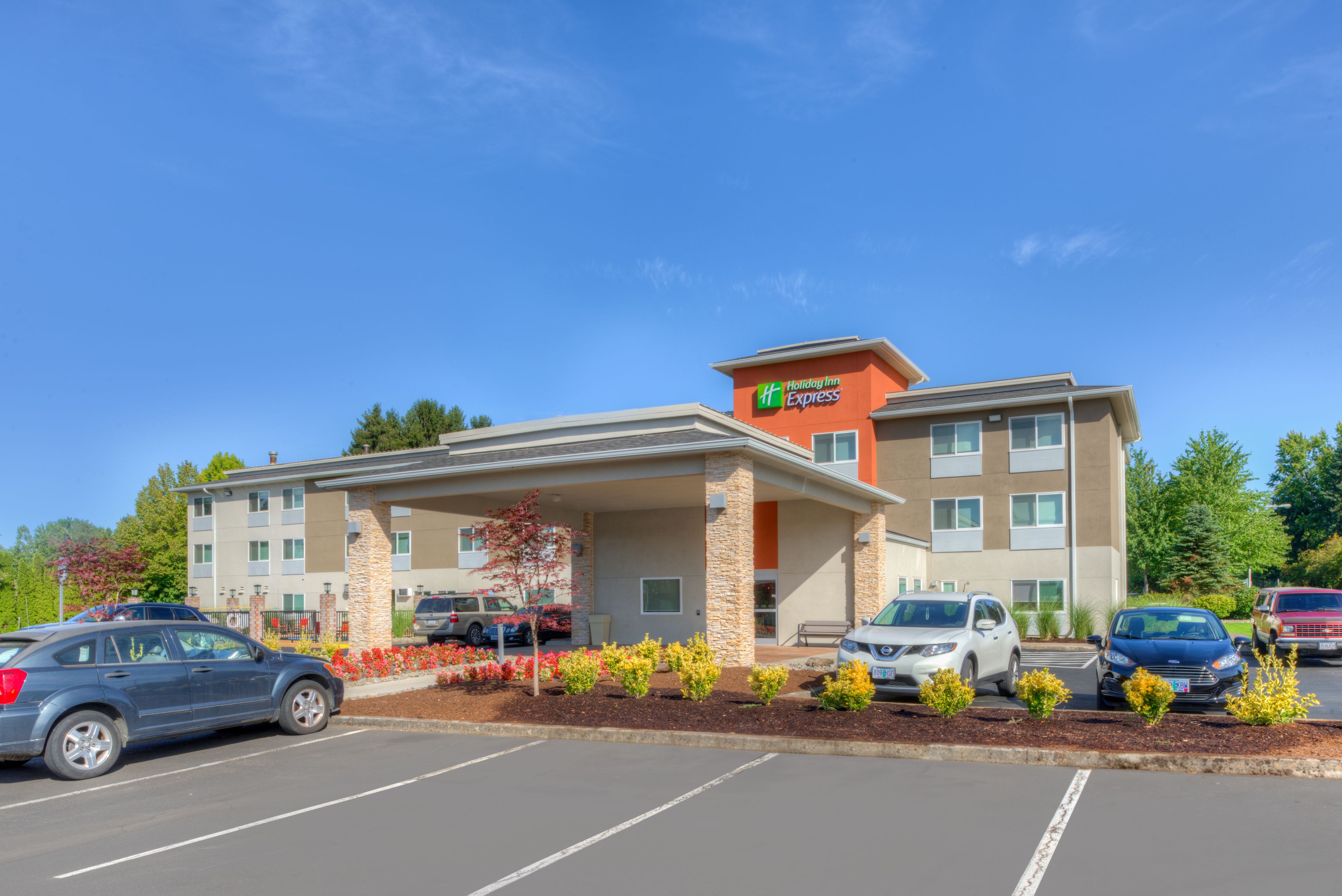 Een Holiday Inn Express hotel met een parkeerplaats en een overdekt buitengebied.
