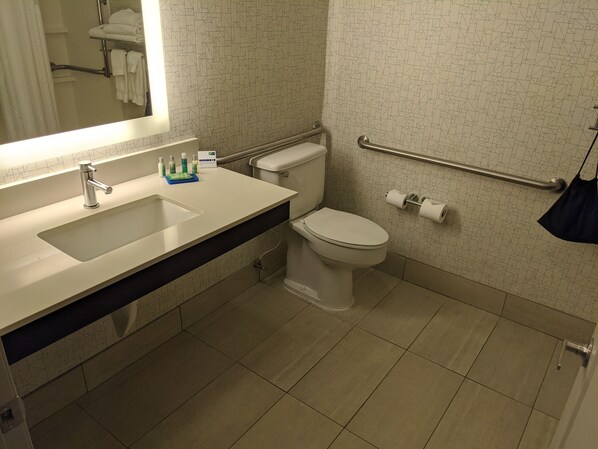 Un baño moderno con lavamanos, inodoro y barandilla.