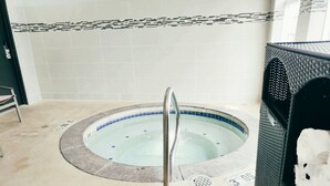 A hot tub with a metal ladder, tiled walls, and a drain cover. - Holiday Inn Express Newberg - Wine Country by IHG (Newberg)