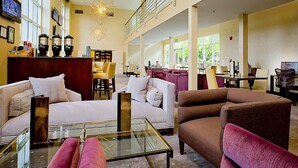 A spacious lobby with multiple seating areas, a reception desk, and large windows offering natural light. - Cupertino Hotel (Cupertino)