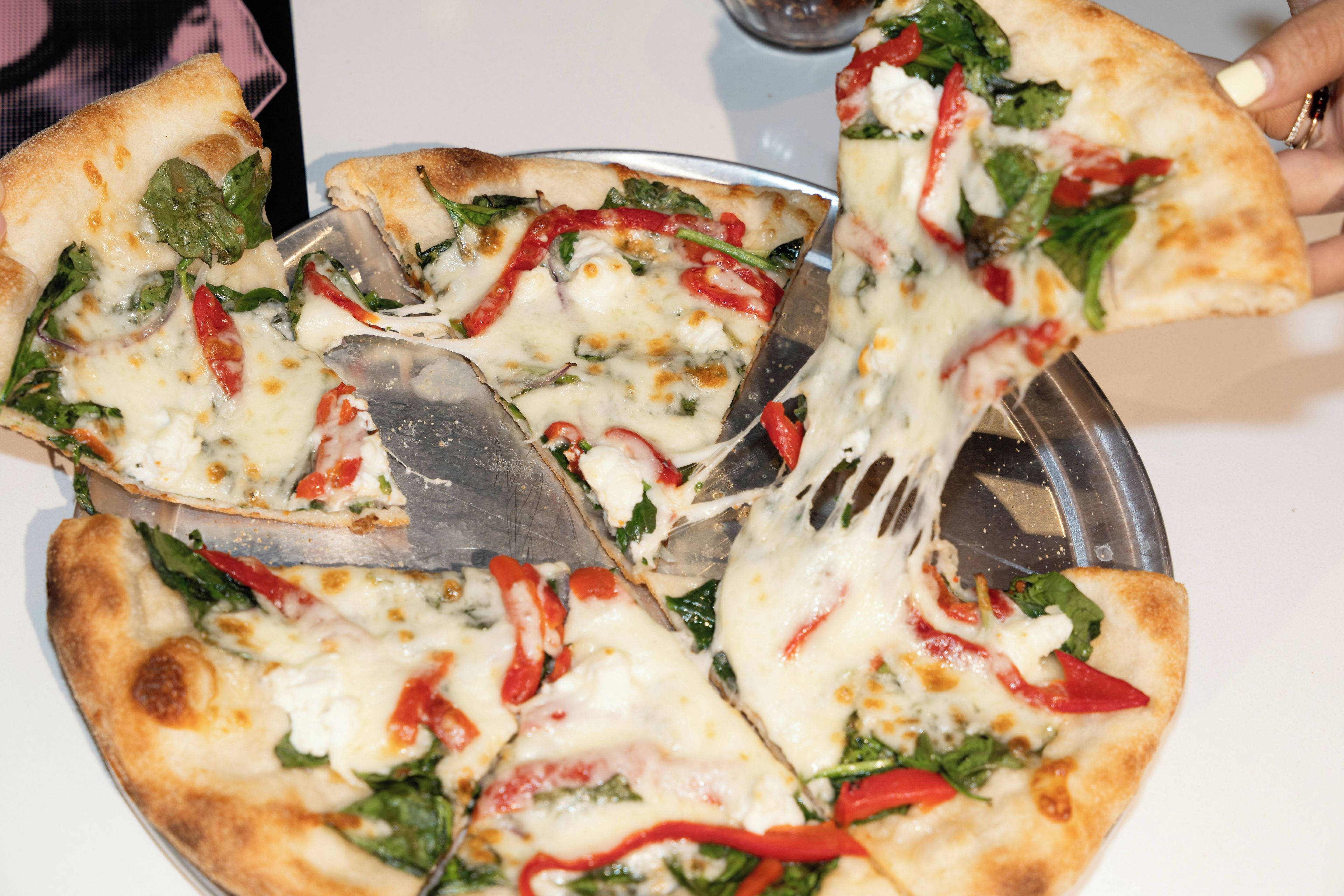 Una pizza con distintos ingredientes sobre una bandeja metálica.