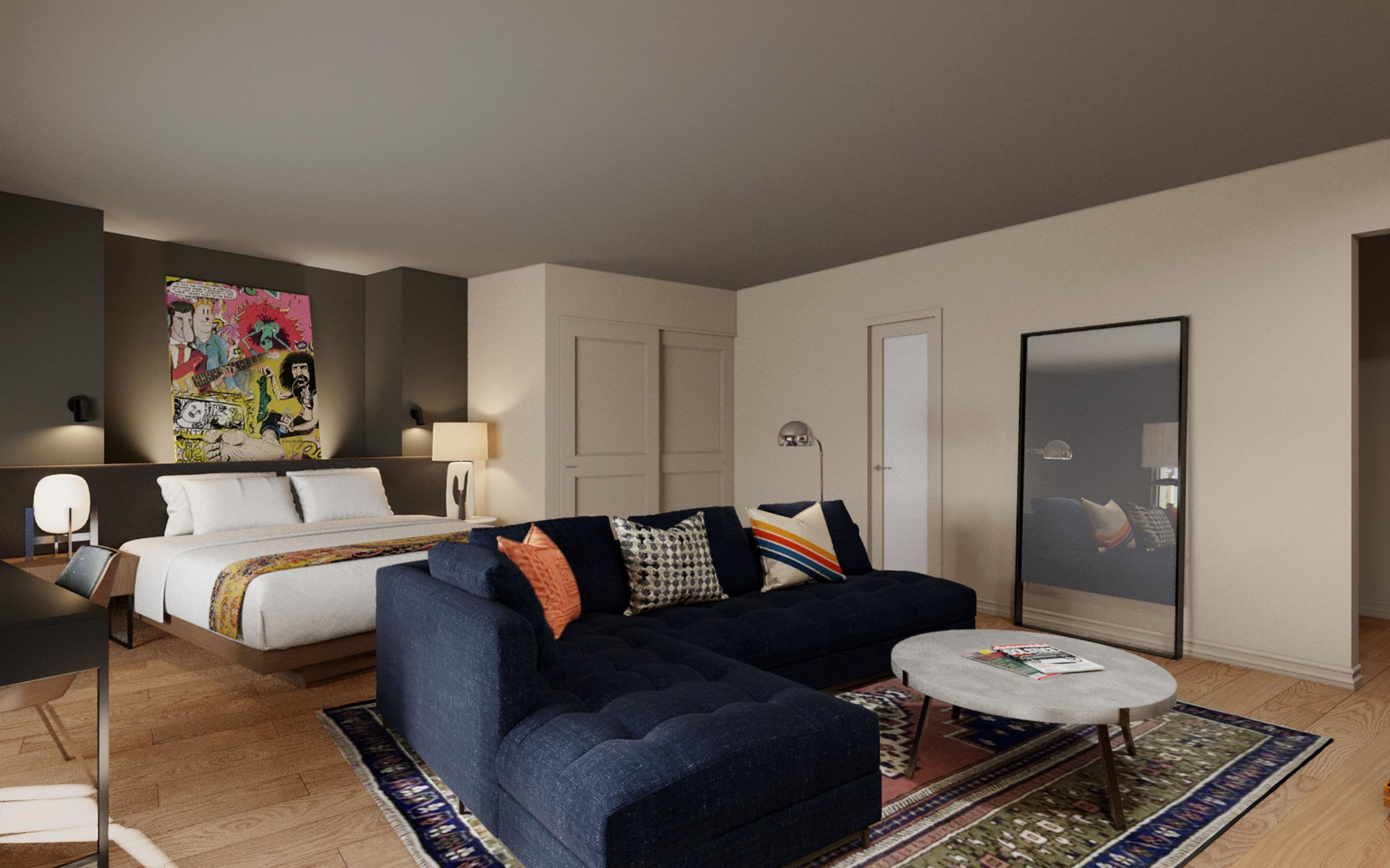 Ett modernt hotellrum med en säng, en soffa, ett soffbord, en lampa och en stor spegel.