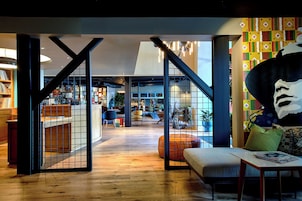 Un interior moderno con una escalera, una zona de estar y un mural grande.