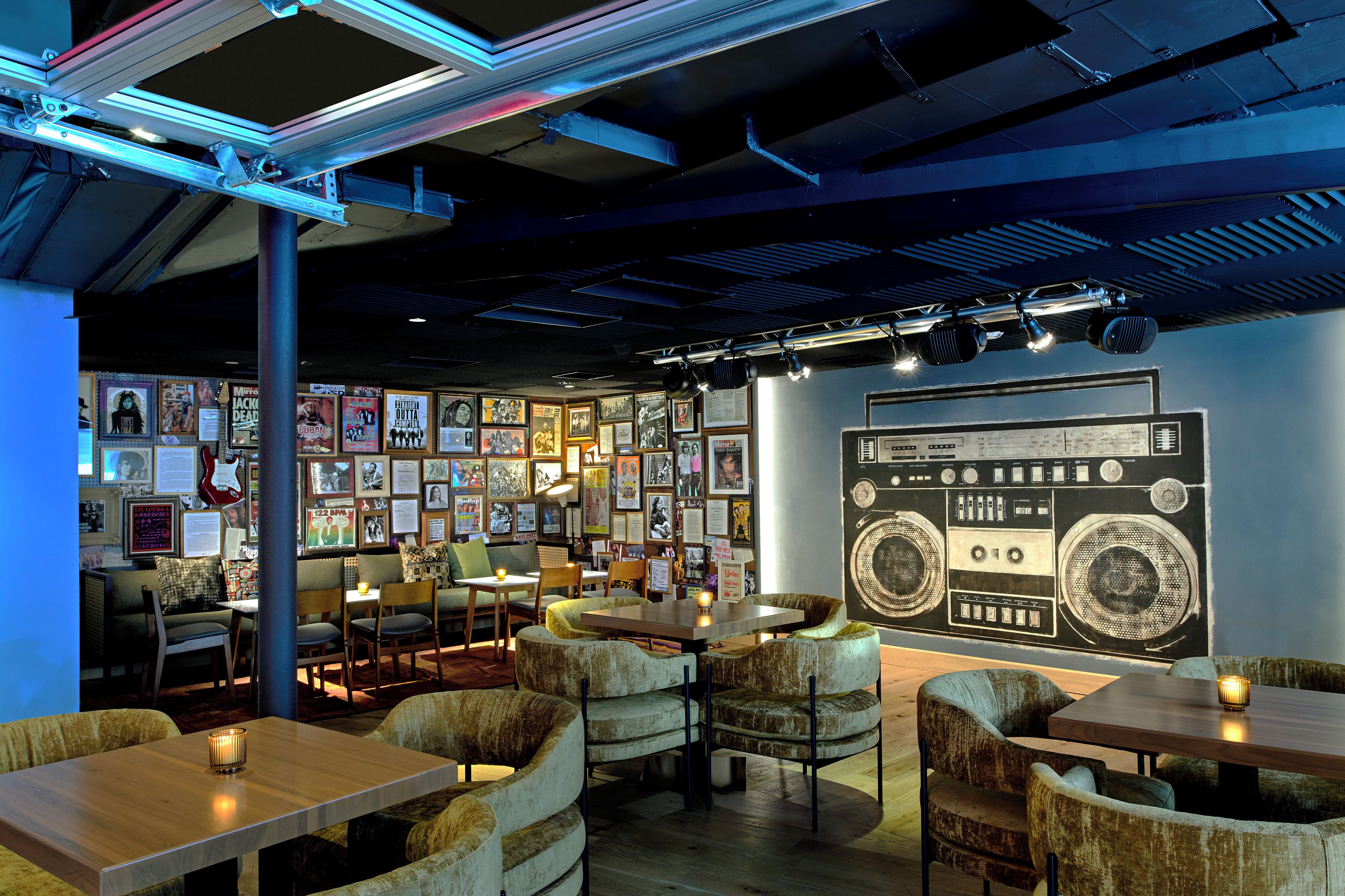 A cozy cafe with vintage decor, including a large radio mural, comfortable seating, and a warm ambiance.