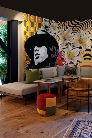 A modern living room with a sofa, ottoman, and wooden coffee table. - Hotel Ziggy on Sunset (West Hollywood)