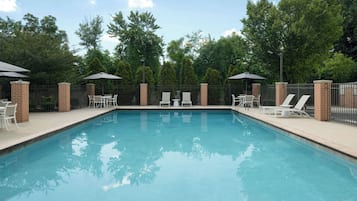 Una piscina al aire libre de temporada, sillones reclinables de piscina