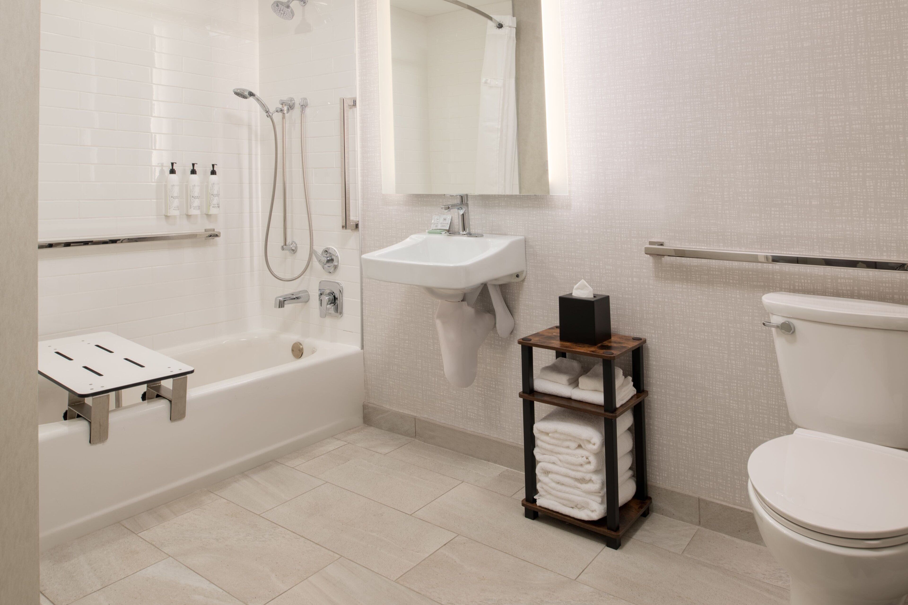A modern bathroom with a bathtub, shower, sink, and toilet.
