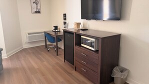 A room with a desk, chair, microwave, and a TV mounted on the wall. - Quality Inn Harrodsburg (Harrodsburg)