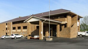 A two-story brick building with a flat roof, a covered entrance, and a flagpole. - Quality Inn Harrodsburg (Harrodsburg)