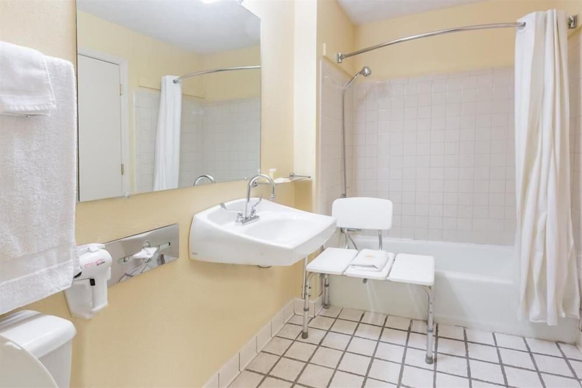 Un baño con lavabo, espejo, inodoro y ducha.