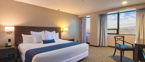 Una habitación de hotel con una cama grande, un escritorio y una silla.