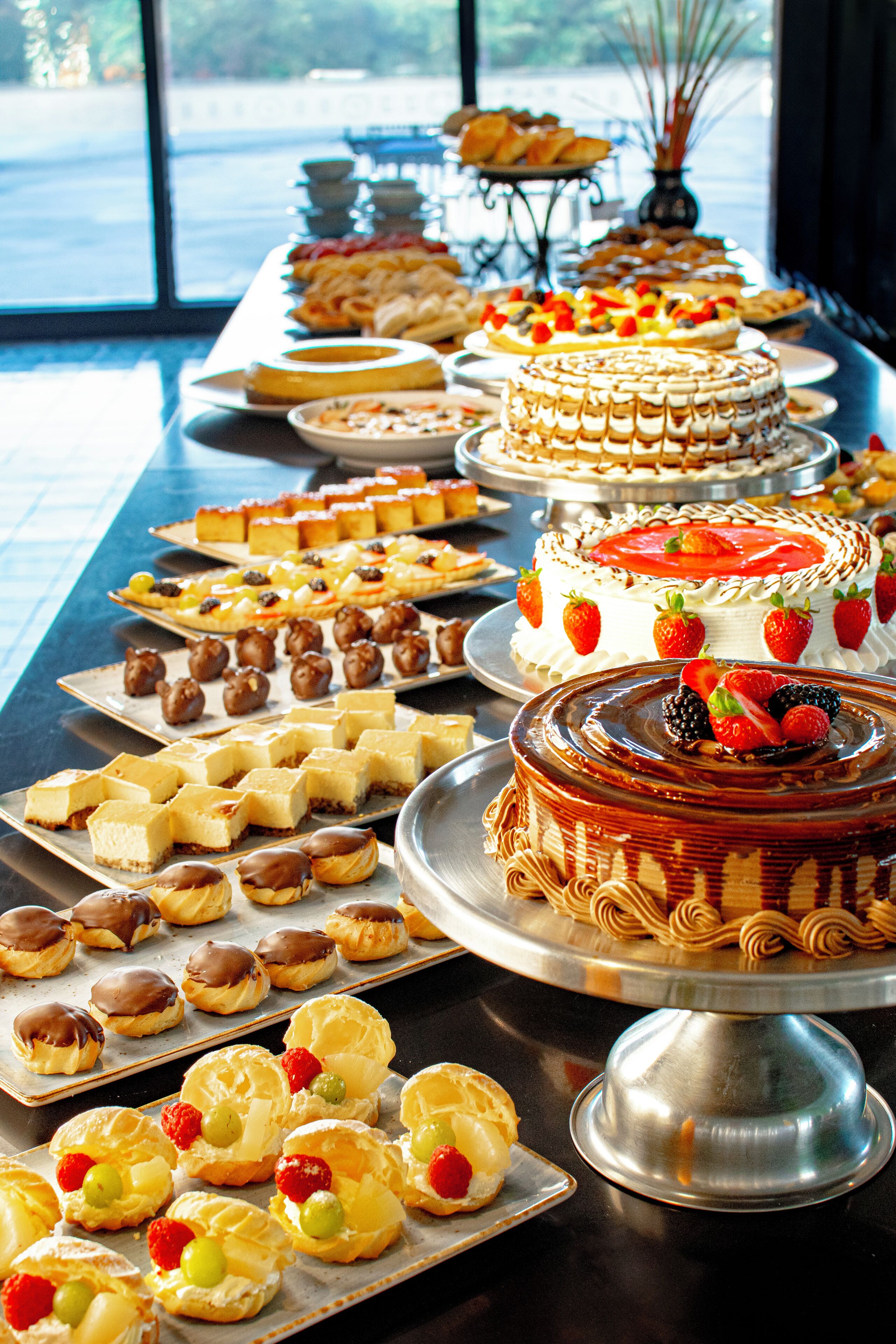 Una mesa de bufé con diversos postres y pasteles.