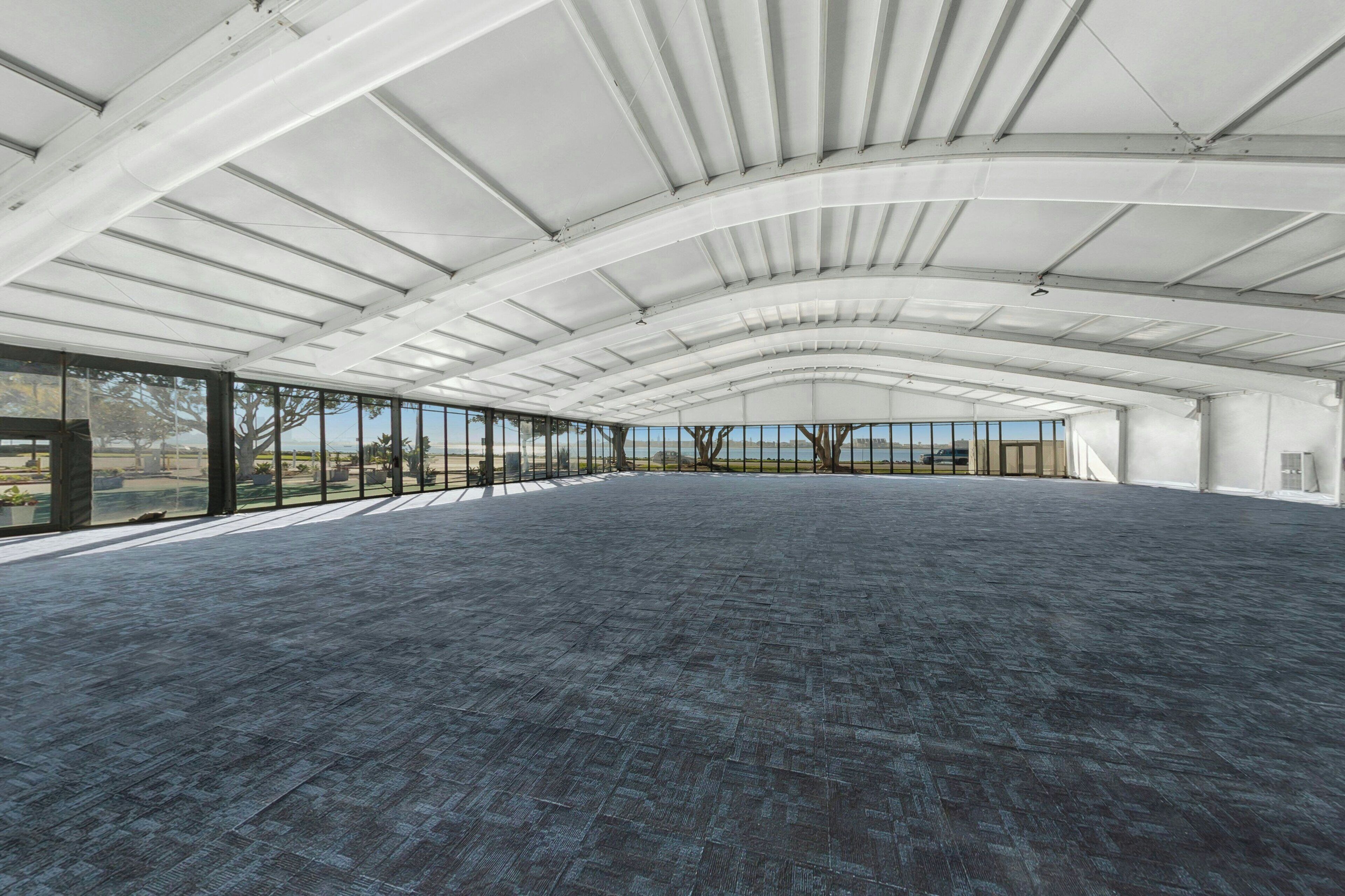 An indoor space with a high ceiling and large windows.