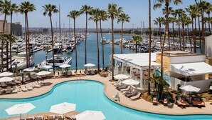 A resort with a large swimming pool, lounge areas, and a marina in the background. - Sheraton San Diego Resort (San Diego)