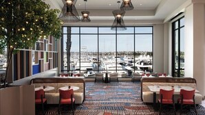 A modern restaurant with a view of a marina, featuring geometric wall panels, patterned flooring, and contemporary pendant lighting. - Sheraton San Diego Resort (San Diego)