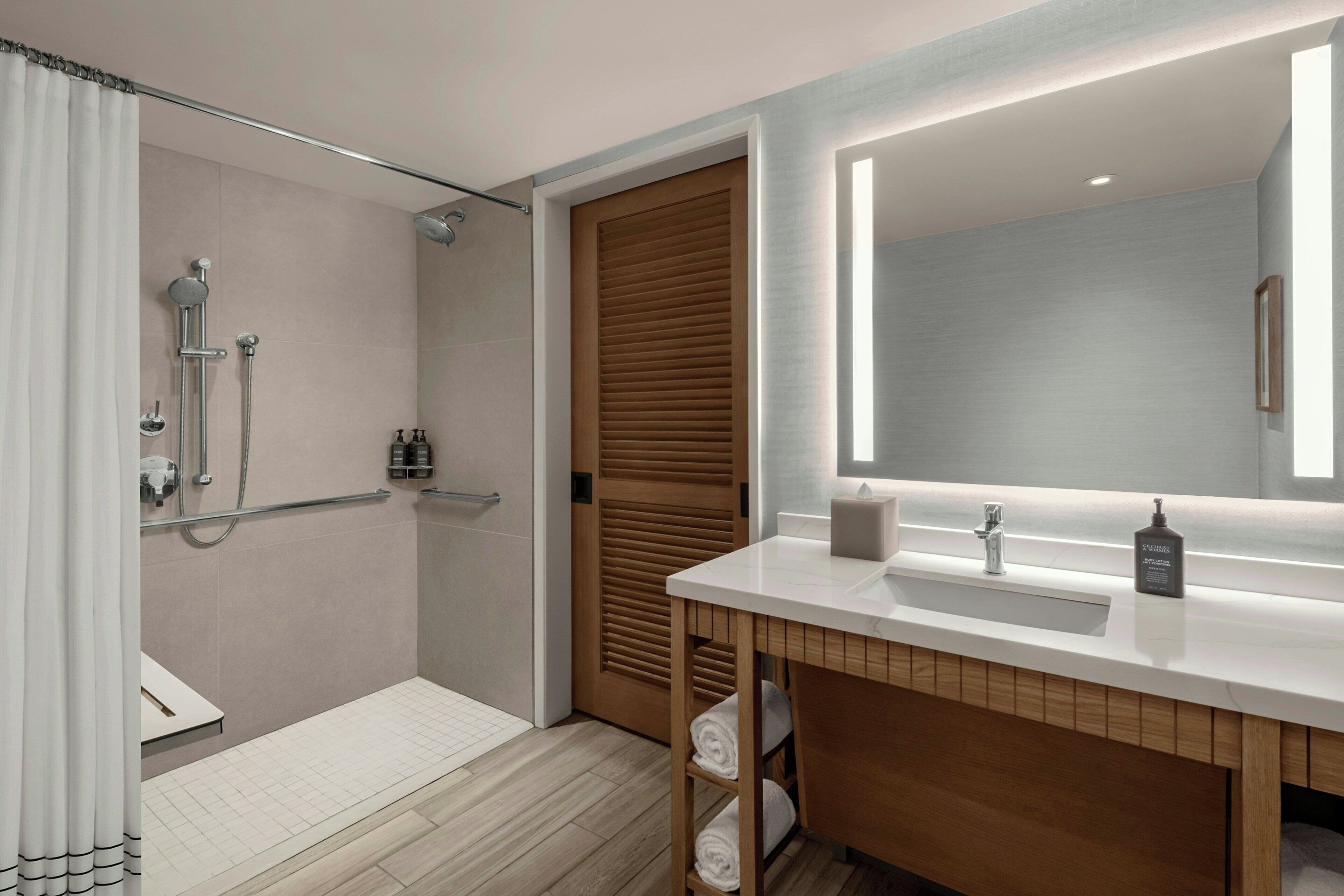 A modern bathroom with a shower, toilet, and sink.