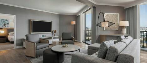 A modern living room with a grey sofa, a round coffee table, and a TV mounted on the wall.