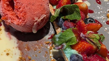 A dessert with ice cream and fresh berries on a plate.