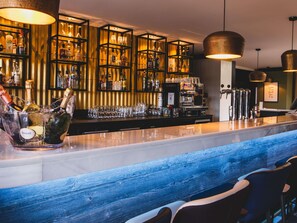 A bar area with a marble countertop, a bottle of Ruinart champagne, and a coffee machine. - Mercure Pau Palais Sports (Pau)