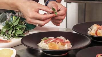 A person preparing food, specifically arranging leaves on a dish.