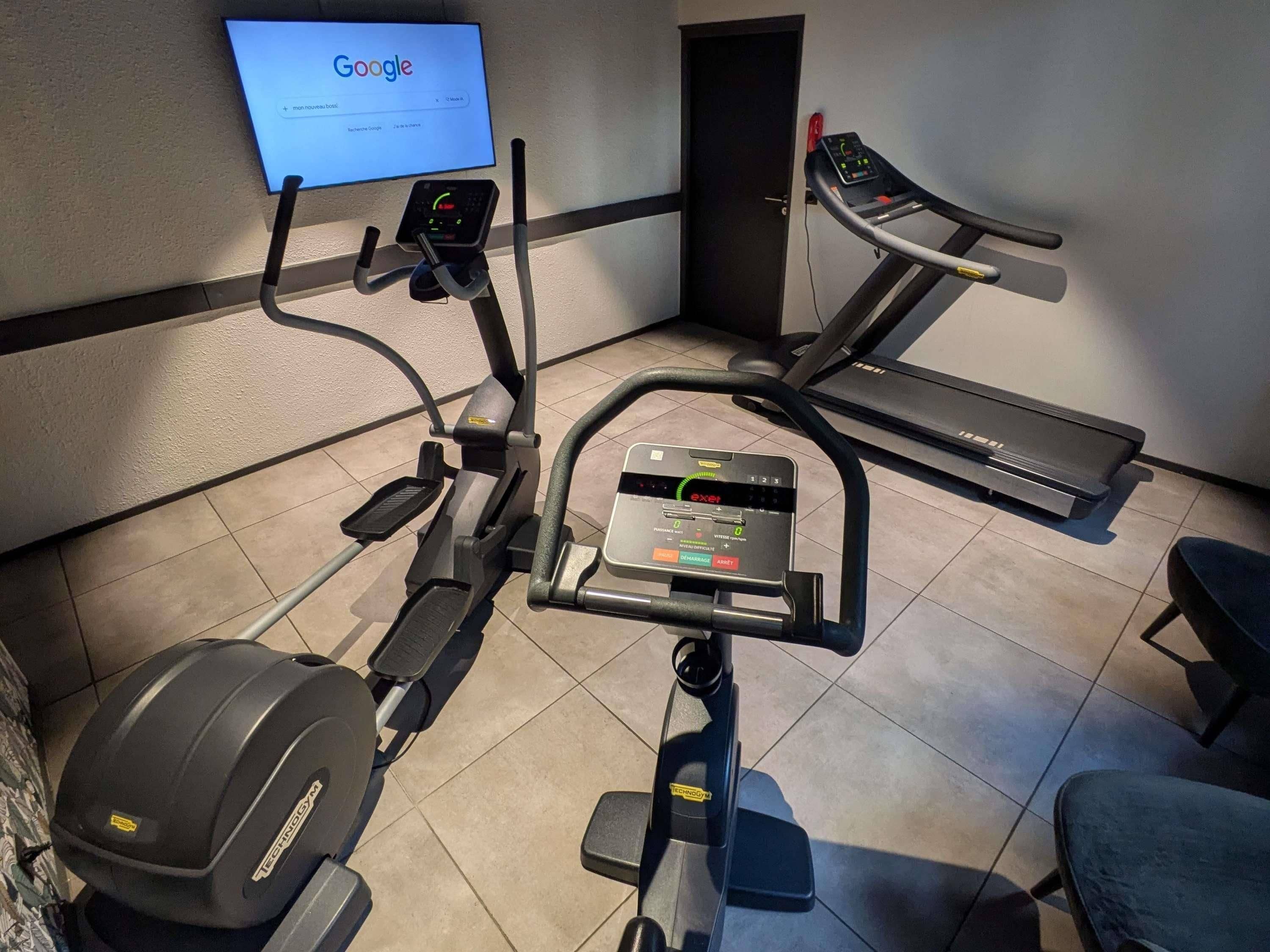 A gym with a treadmill, elliptical, and weight machine.