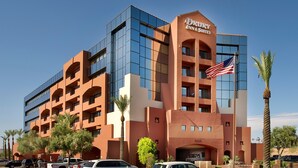 A Drury Inn & Suites building with a modern design, featuring a prominent American flag and a clear view of the parking area. - Drury Inn & Suites Phoenix Airport (Phoenix)