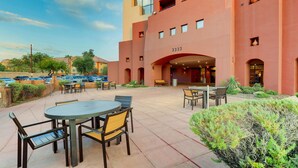 A building with a large entrance, outdoor seating area, and a parking lot. - Drury Inn & Suites Phoenix Airport (Phoenix)