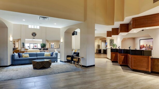 A spacious lobby with a reception desk, seating area, and a large window providing natural light. - Drury Inn & Suites Phoenix Airport (Phoenix)
