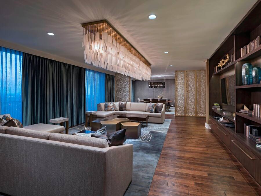 A modern living room with a sectional sofa, a coffee table, and a bookshelf.