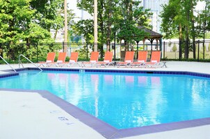 Una piscina con lettini e un gazebo.