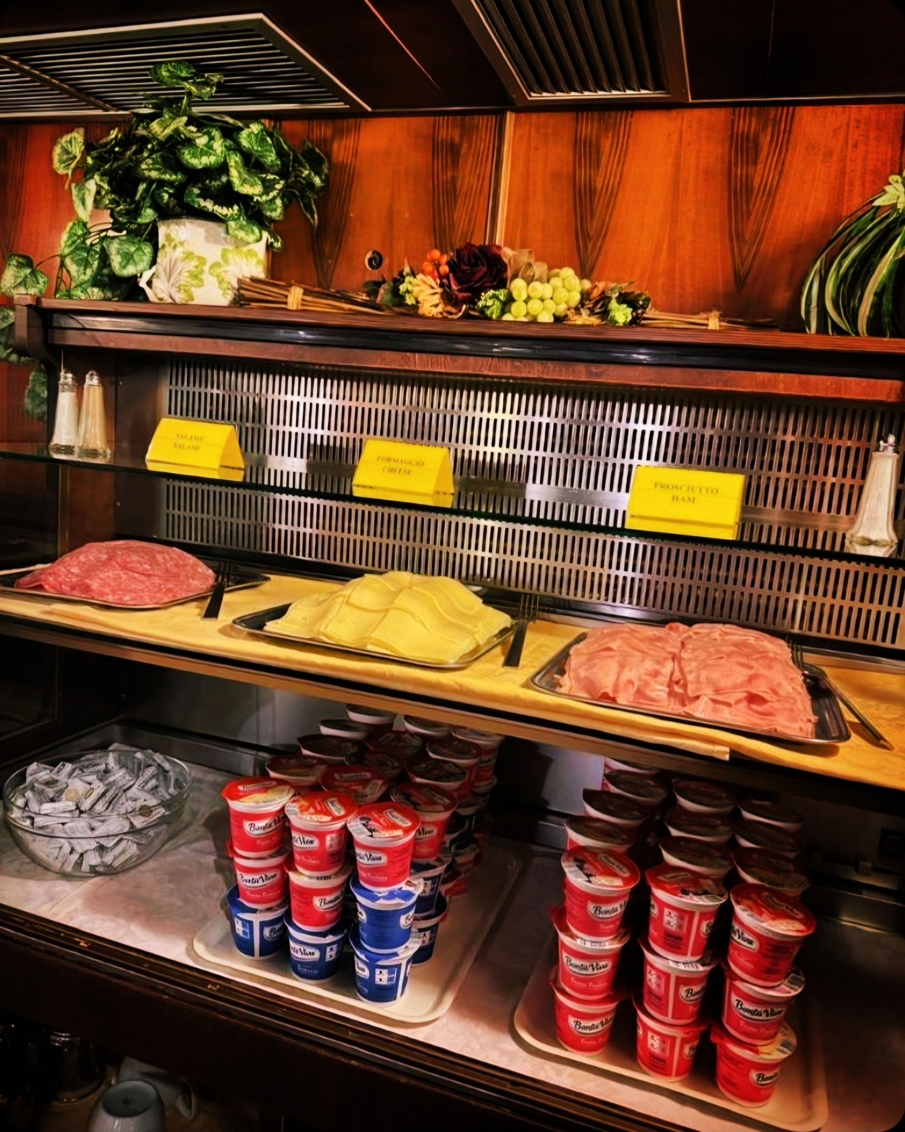 Un comptoir de charcuterie proposant une variété de viandes, de fromages et de condiments.